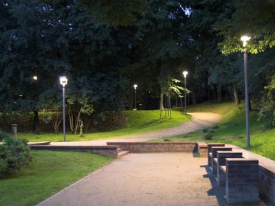 Oświetlona alejka z ławkami nocą, Ogród Różany w Szczecinie