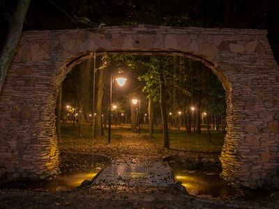 Brama i oświetlona alejka nocą, park pałacowy w Poddębicach