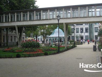 Alejka przy budynku z przeszklonym łącznikiem, park przy molo w Sopocie